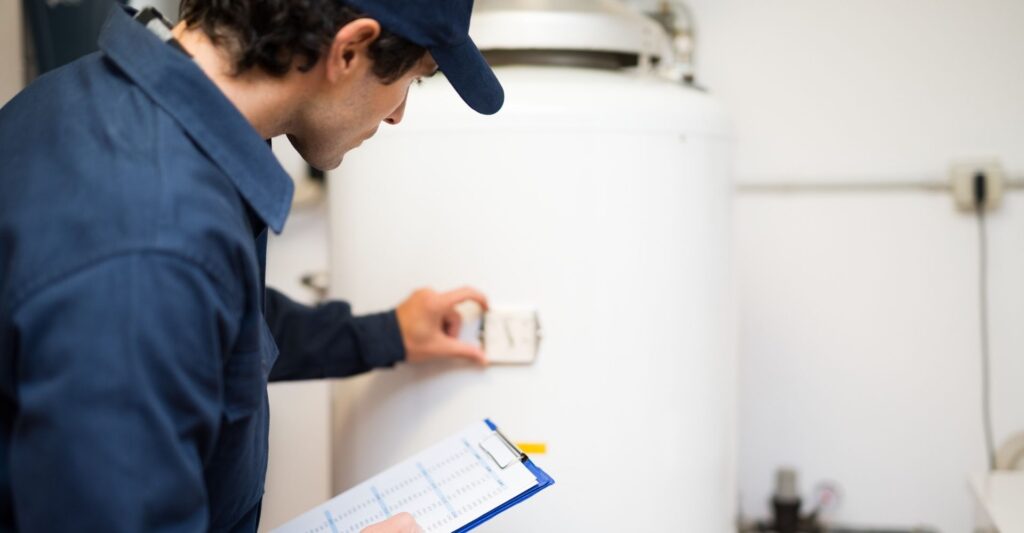 Man performing maintenance on a water heater.