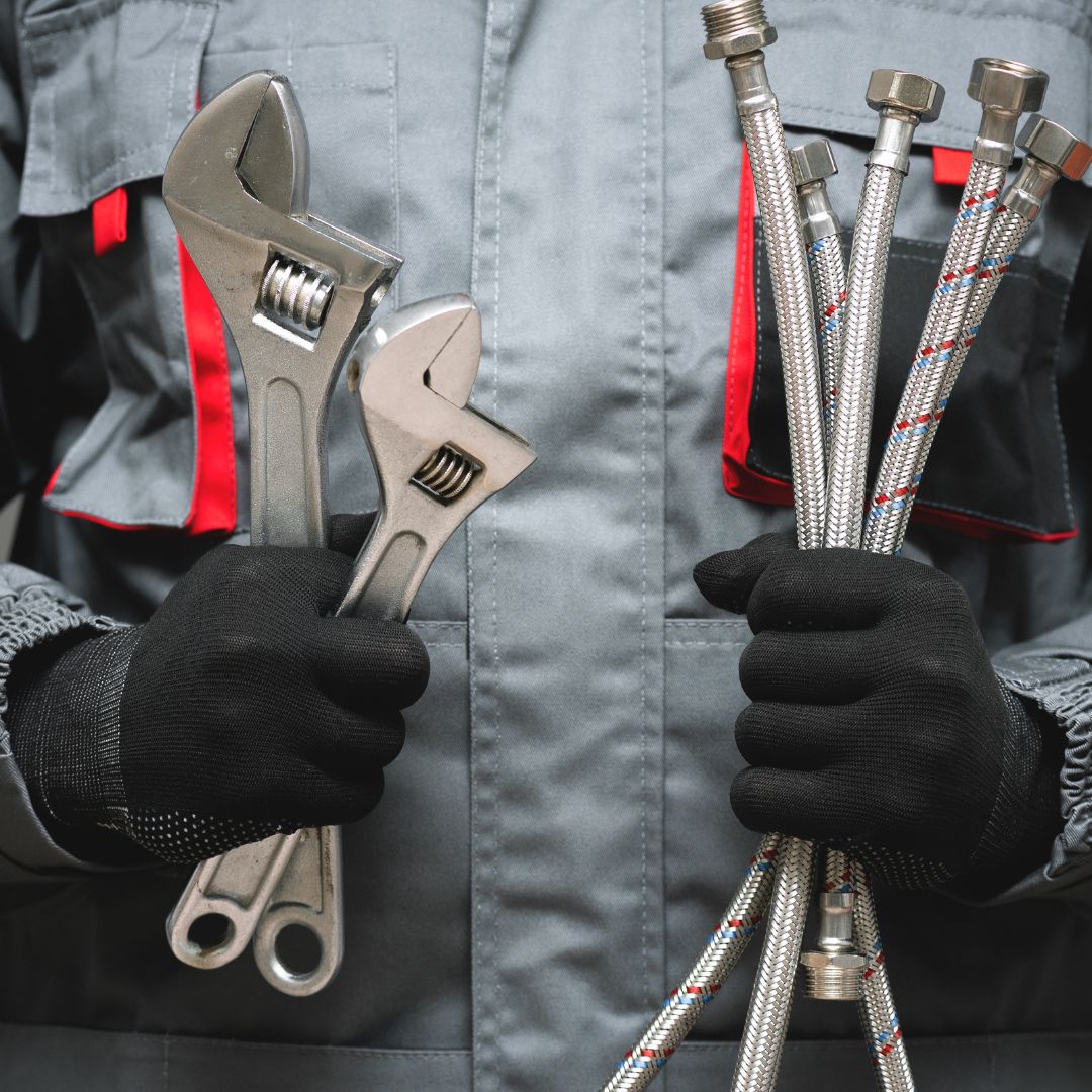 a plumber holding tools and equipment needed to fix something