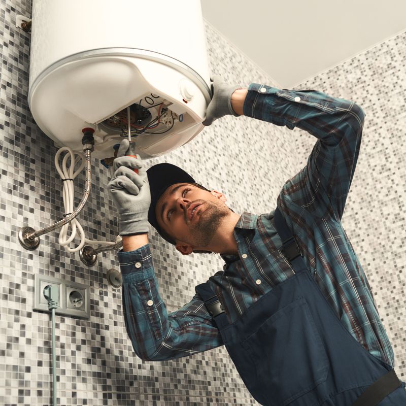 a man using a screwdriver to adjust a boiler
