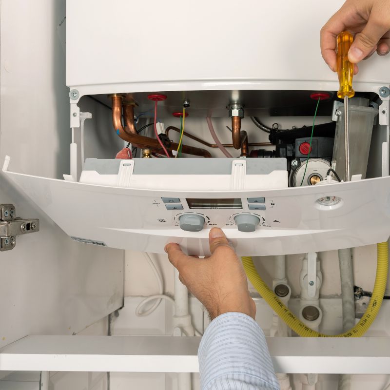 a person opening a boiler for repair