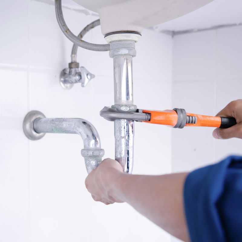 a person using a pipe wrench on a pipe