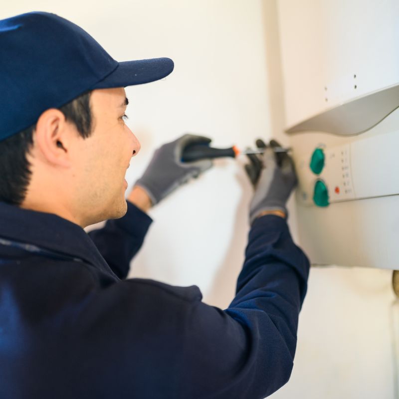 a man unscrewing a tankless water heater