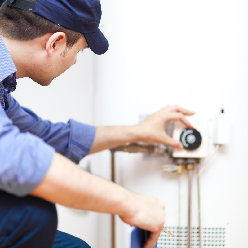 a man adjusting the temperature of a water heater