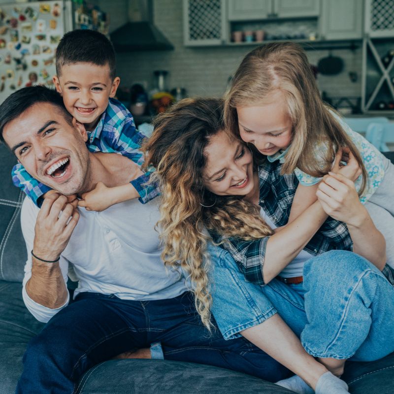 A happy family hugging on a couch